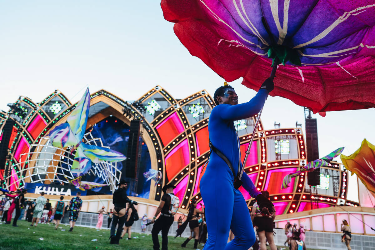 A performer holds up a gigantic flower during day one of Electric Daisy Carnival at the Las Veg ...