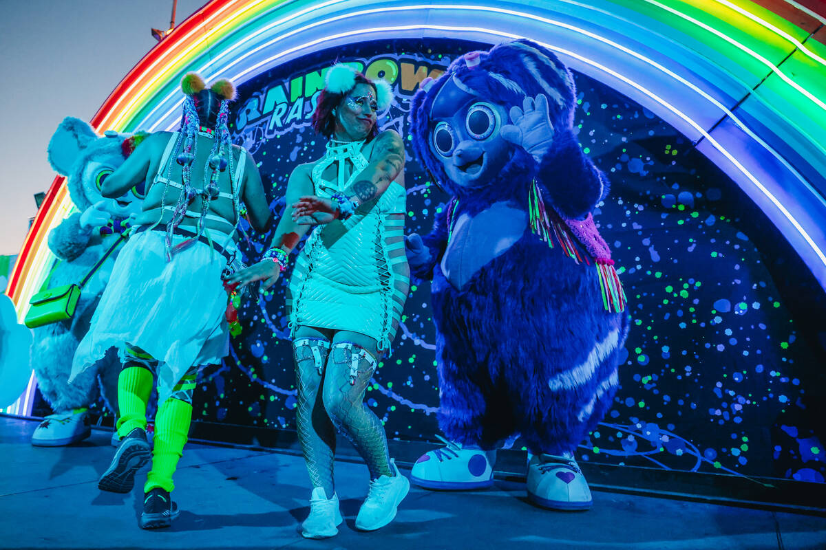 Festival attendees dance with the Rainbow Rascal mascots during day one of Electric Daisy Carni ...