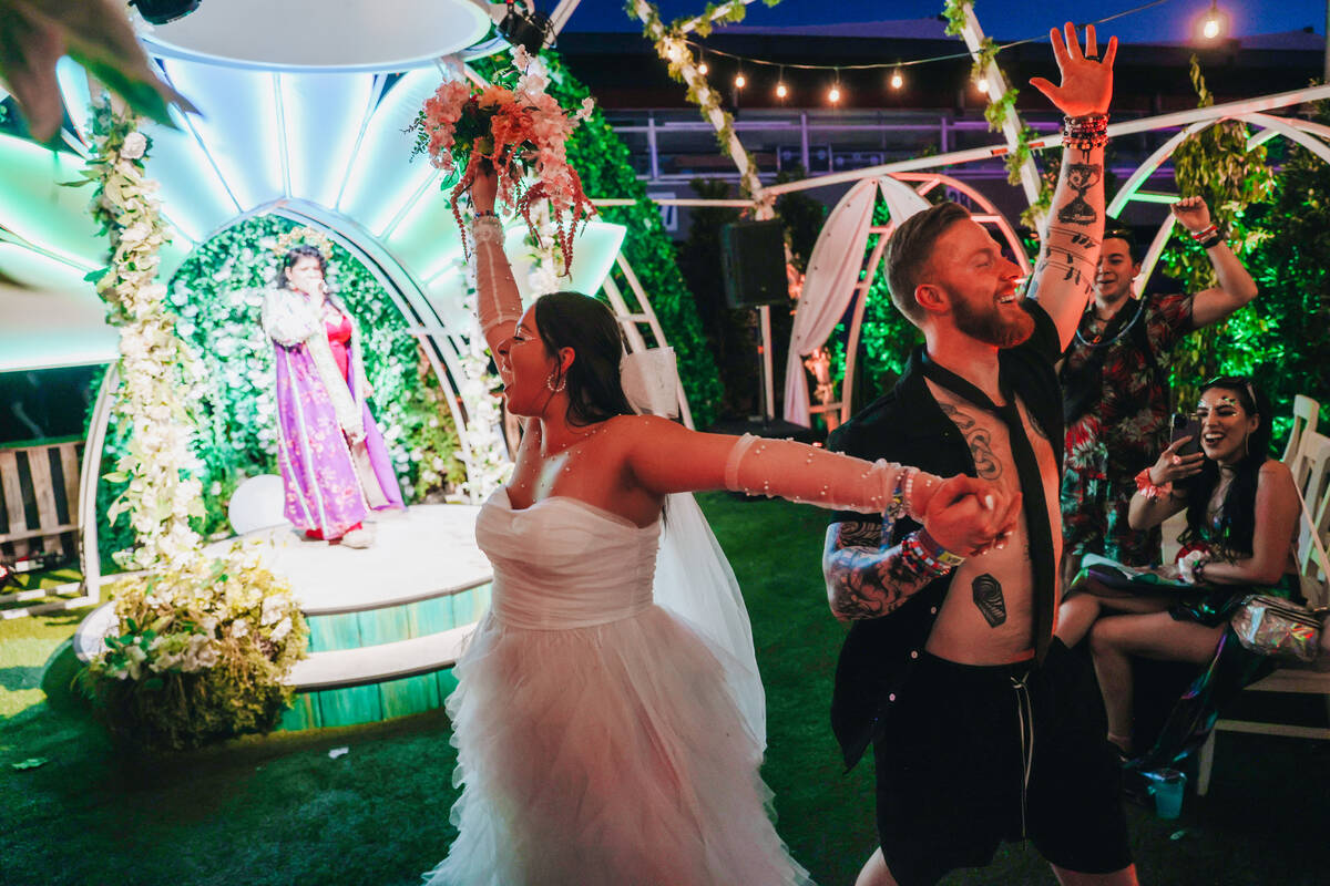 A couple walks down the aisle after getting married during day one of Electric Daisy Carnival a ...