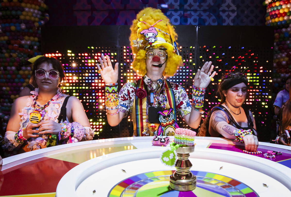 A performer, center, watches as a roulette-style wheel with Kandi bracelets spins during the fi ...