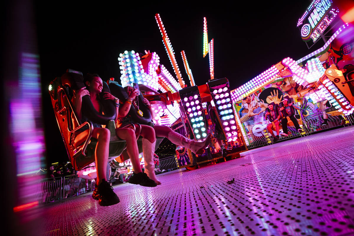 Attendees try out a carnival ride during the first night of the Electric Daisy Carnival at the ...