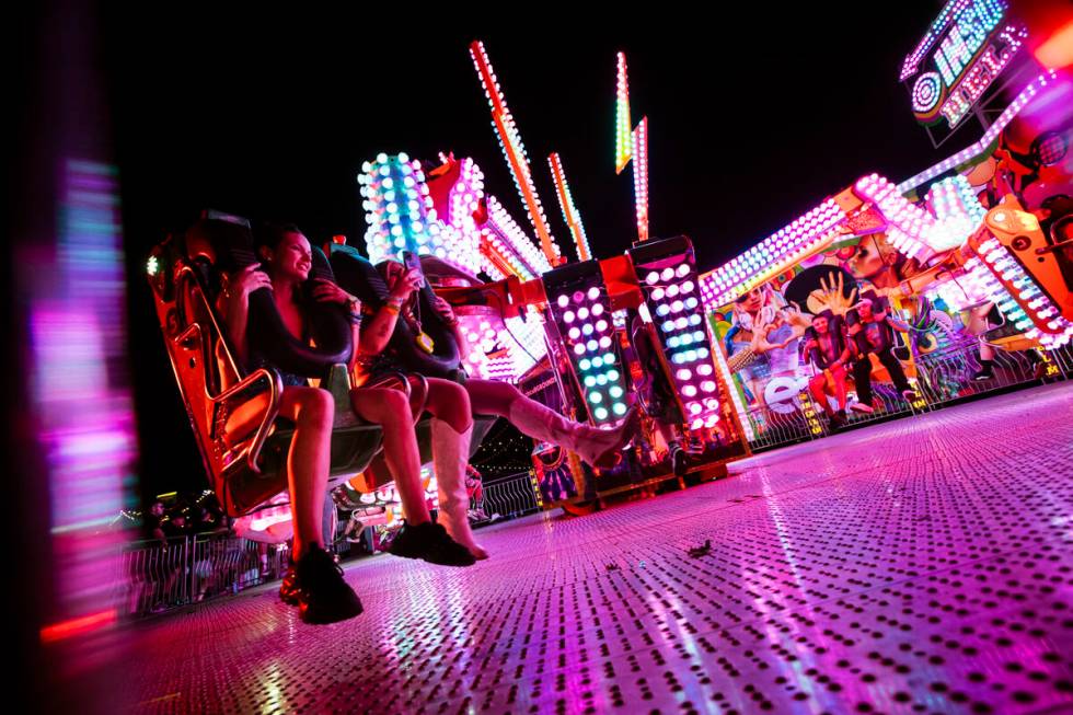 Attendees try out a carnival ride during the first night of the Electric Daisy Carnival at the ...