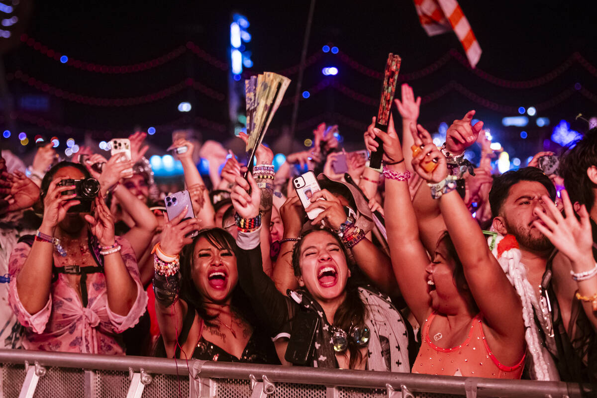 Attendees react as David Guetta takes the Kinetic Field stage during the first night of the Ele ...