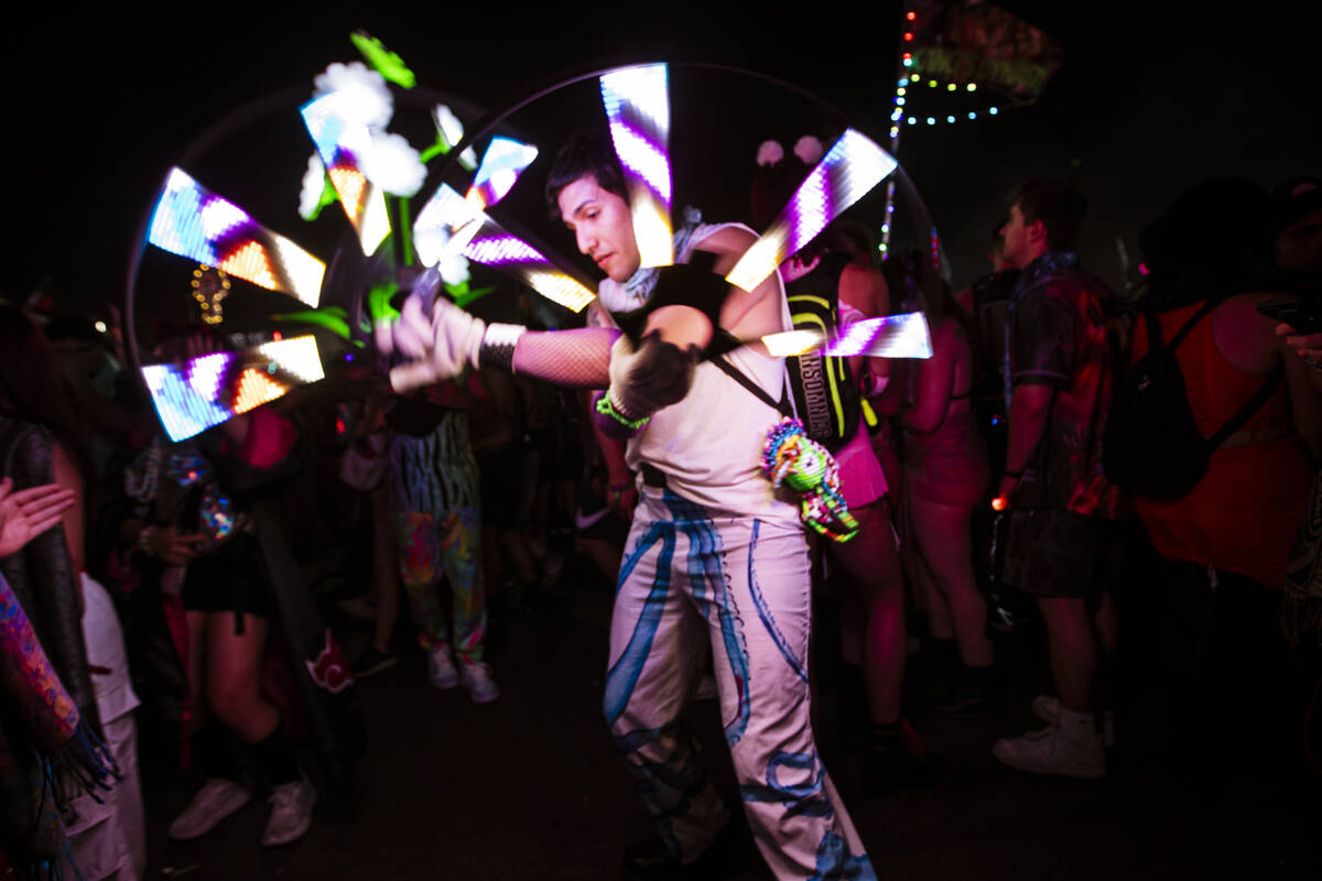 An attendee entertains the crowd with a light show during the first night of the Electric Daisy ...
