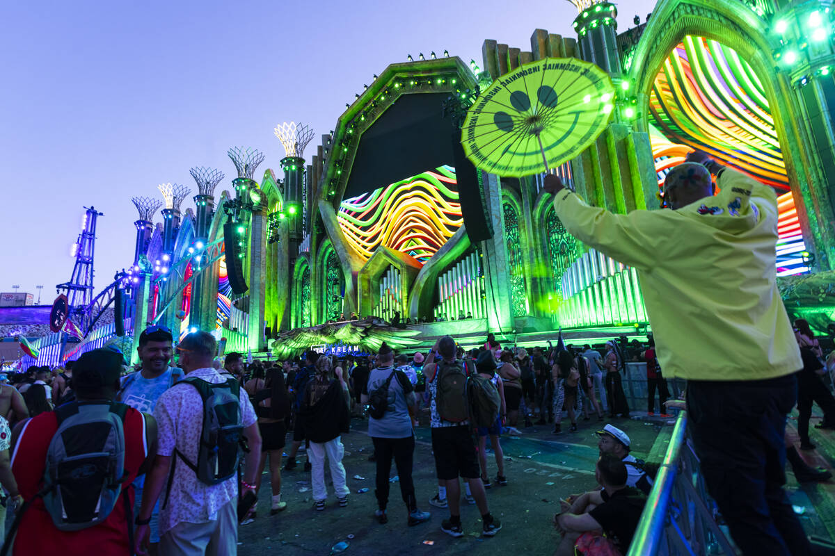 Festival attendees dance at Kinetic Field as the sun begins to rise during the second night of ...