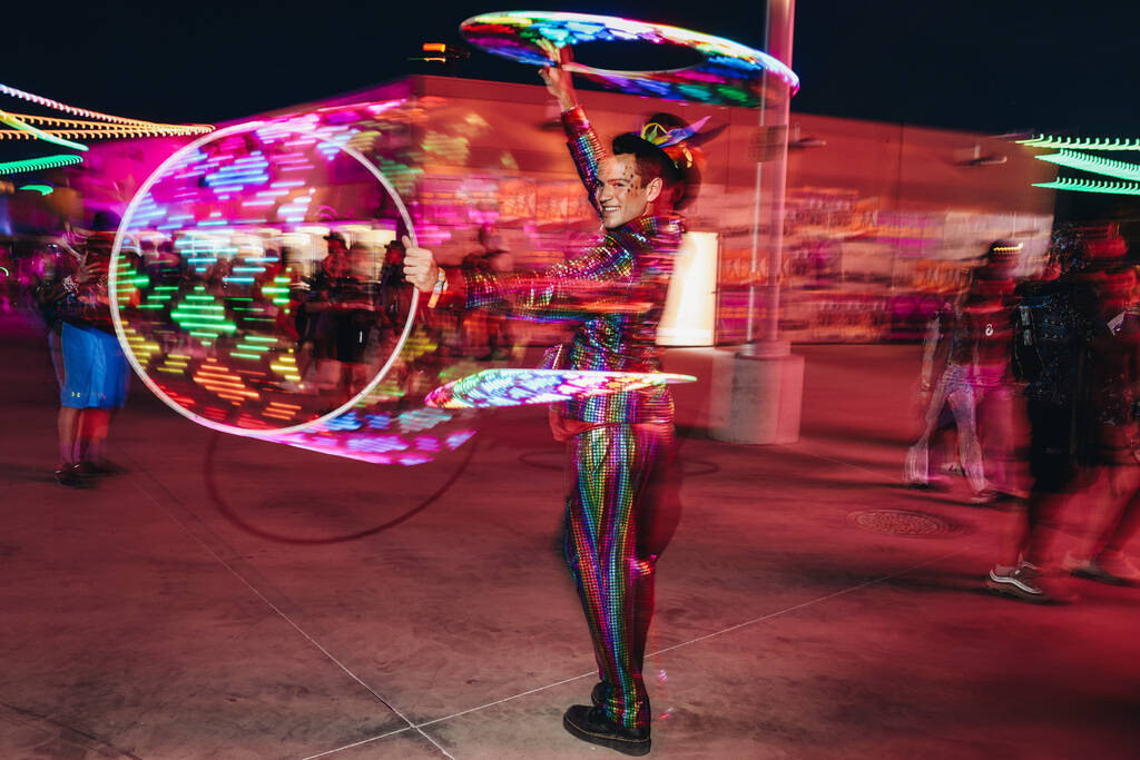 A costumed performer dances with hoola hoops during the second day of the Electric Daisy Carniv ...