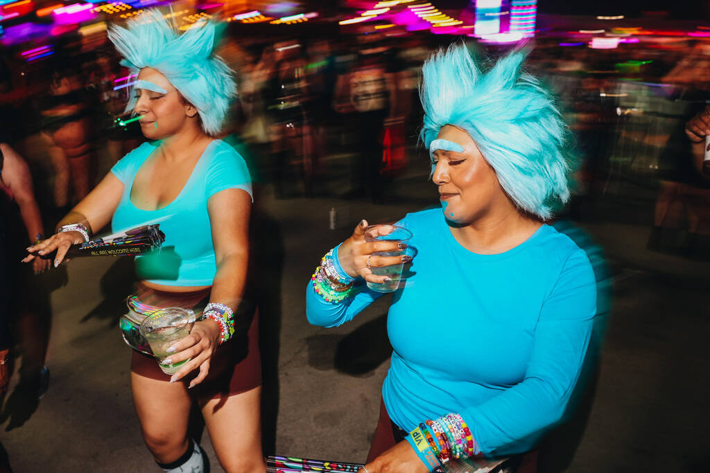 Festival attendees dressed as Rick Sanchez from “Rick and Morty” dance to a DJ se ...