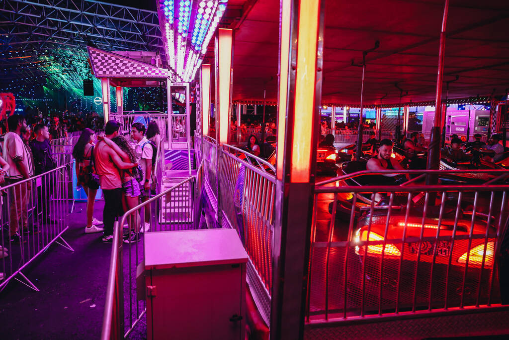 A couple embraces each other as they wait to go on the bumper car ride during the second day of ...