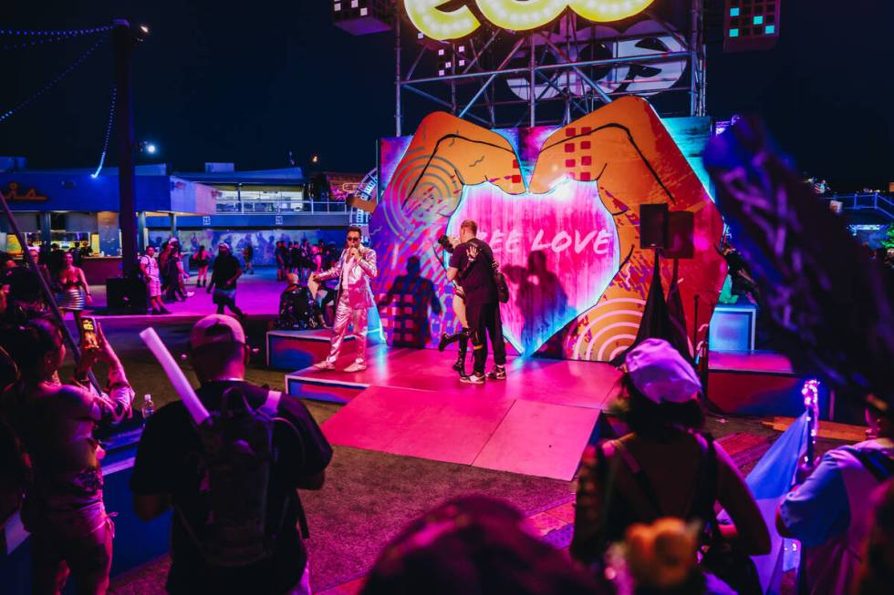 A couple kisses after renewing their vows in an EDC wedding booth on the third and final night ...