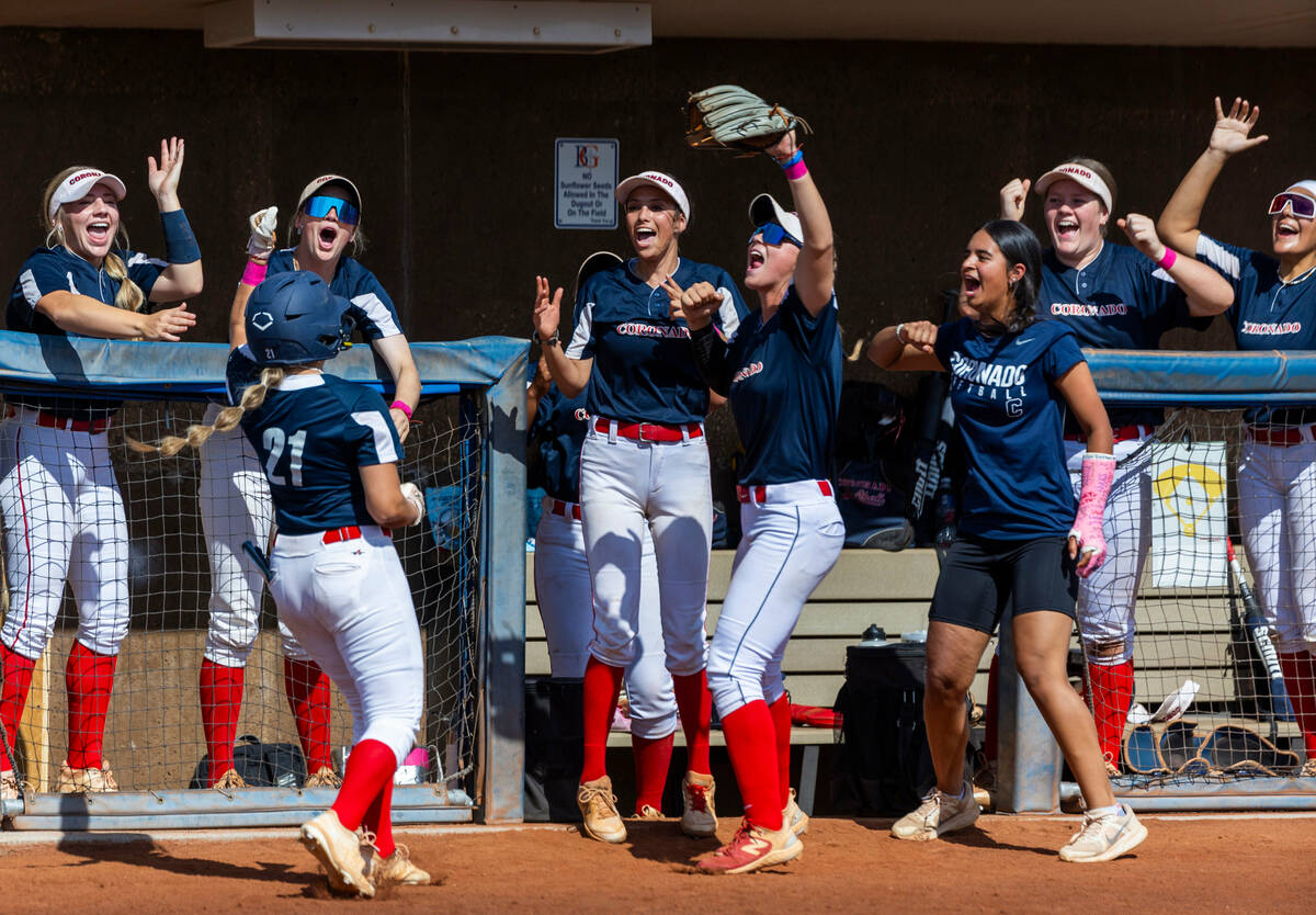 Coronado runner Charlotte Bendlin (21) is celebrated by teammates after sliding into home plate ...