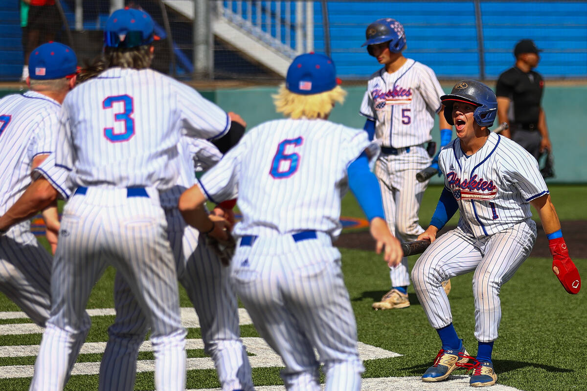 Reno’s Jackson Sellers (1) celebrates with his team after scoring during a Class 5A base ...