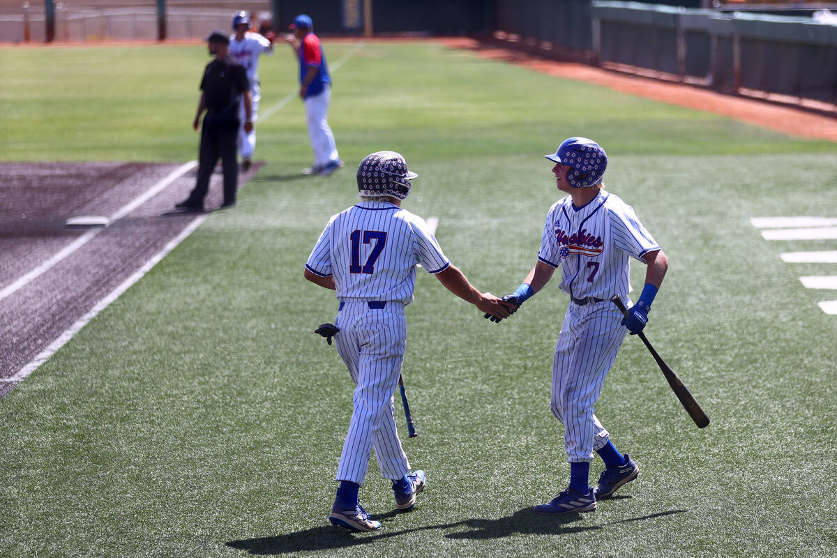 Reno’s Jaydon Loose slaps hands with Logan Ford (7) after scoring during a Class 5A base ...