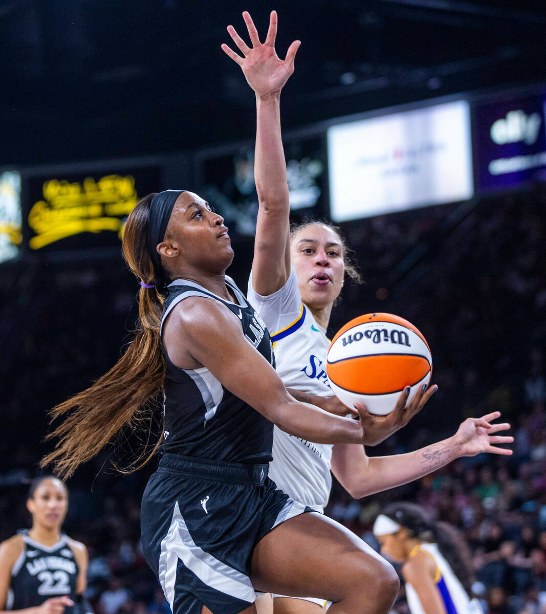 Aces guard Jackie Young (0) battles for a shot against the Los Angeles Sparks forward Dearica H ...