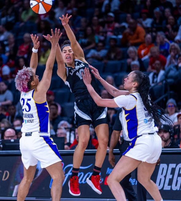 Aces guard Kelsey Plum (10) gets off a pass under double coverage by Los Angeles Sparks guard L ...