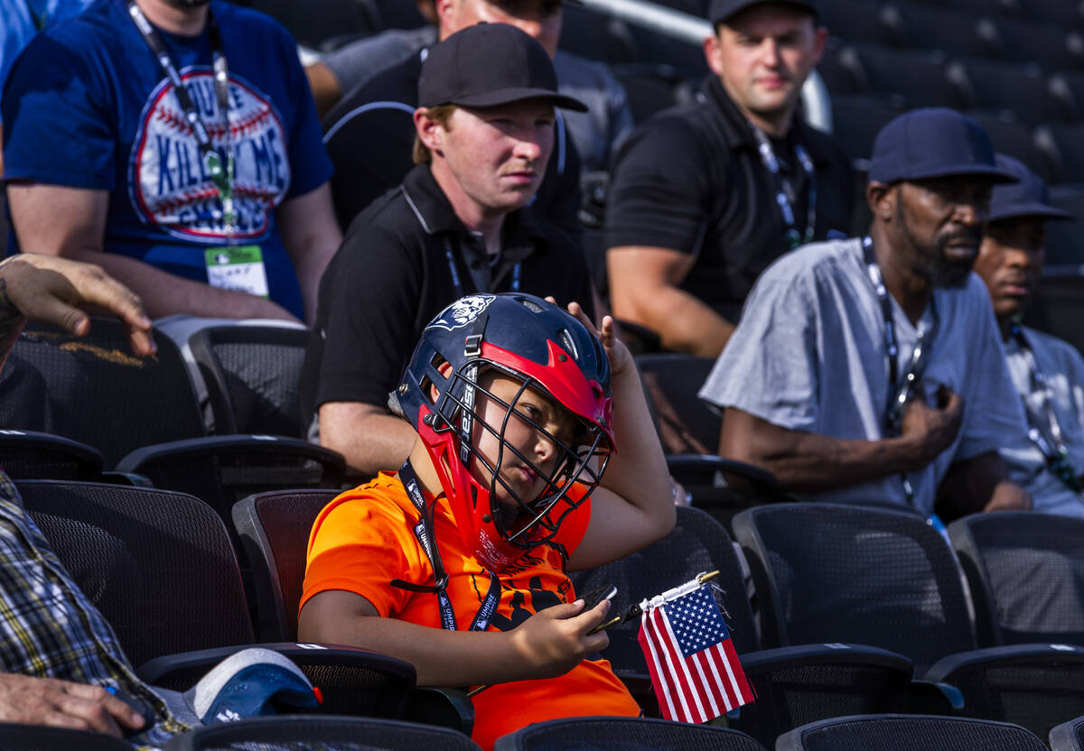 Participants, even young ones, listen to staff instructions during a Major League camp for umpi ...