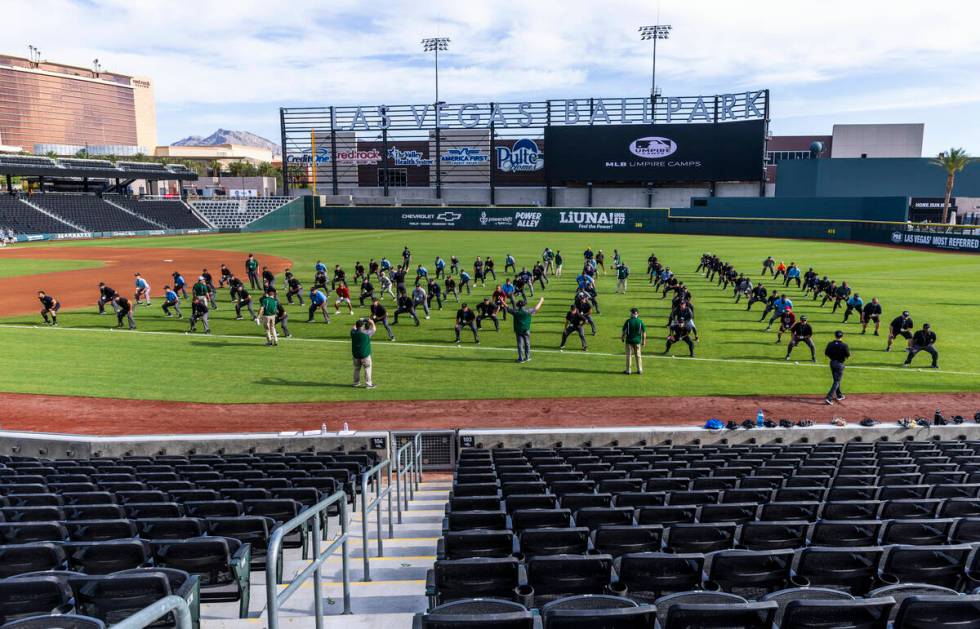 Participants practice their position behind the plate for staff during a Major League camp for ...