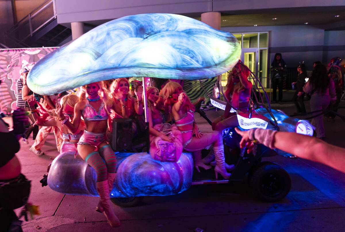 Costumed performers pass by while riding on an art car during the third night of the Electric D ...