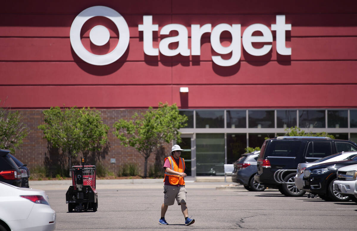 A worker collects shopping carts in the parking lot of a Target store June 9, 2021, in Highland ...