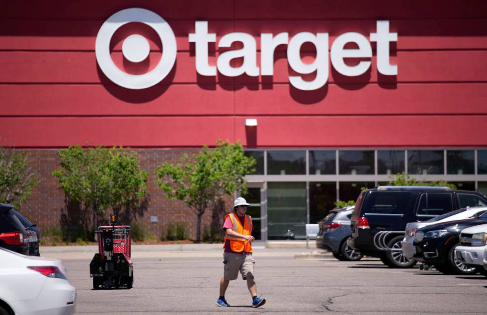 A worker collects shopping carts in the parking lot of a Target store June 9, 2021, in Highland ...