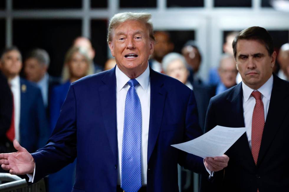 Former President Donald Trump speaks to members of the media before entering the courtroom with ...