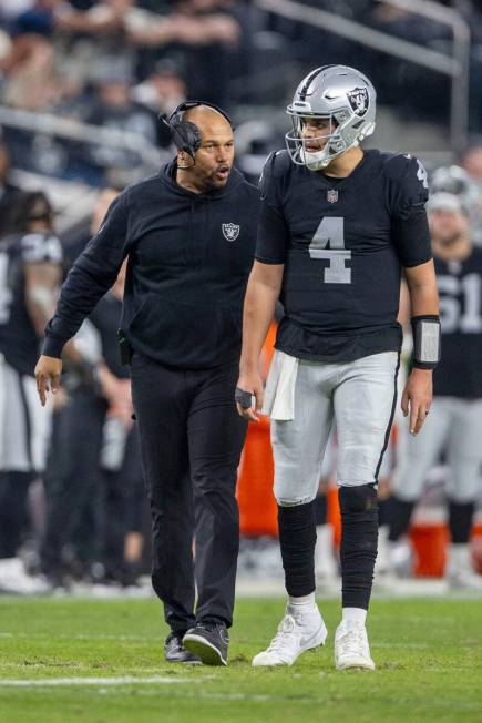 Raiders interim head coach Antonio Pierce works with Raiders quarterback Aidan O'Connell (4) du ...