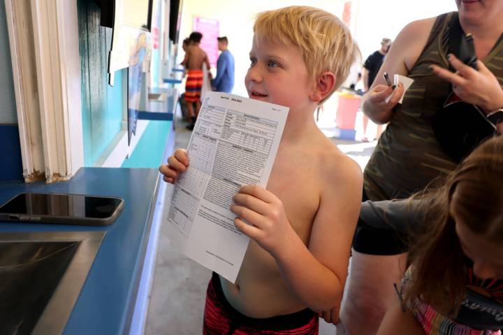 Gavin Andrade 8, of Las Vegas shows his report card for free admission at Cowabunga Bay in Hend ...