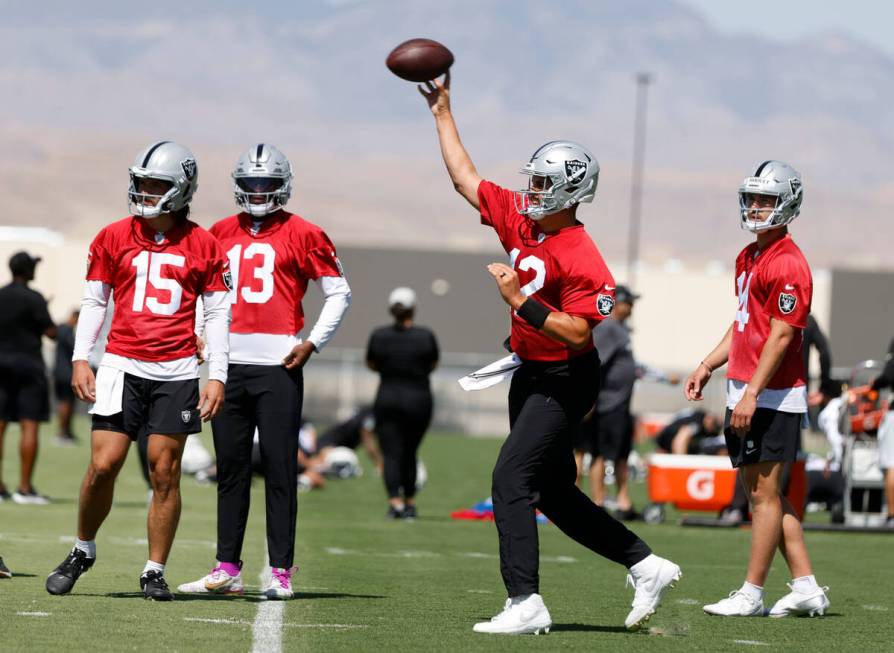 Raiders quarterback Aiden O'Connell (12) throws the ball as backup quarterbacks Gardner Minshew ...