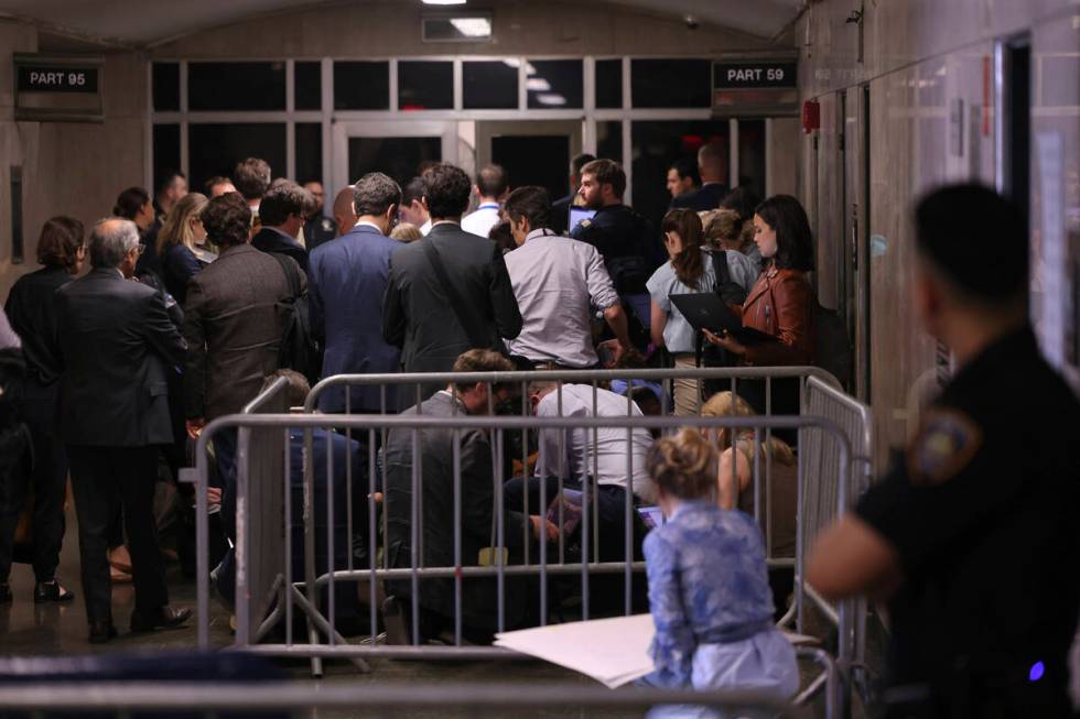 Members of the press and public stand outside the courtroom after being asked to leave by Judge ...