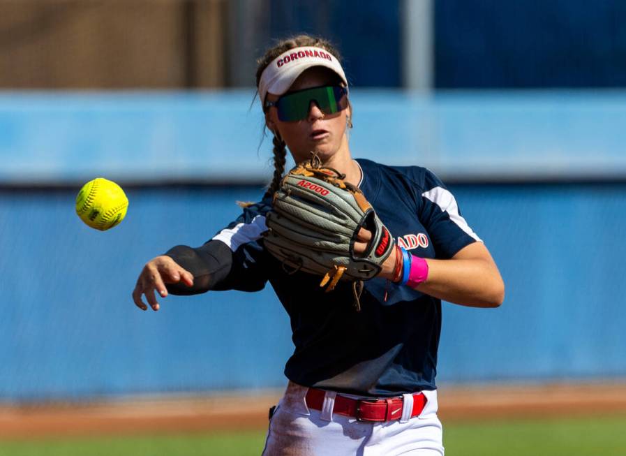 Coronado runner Bailey Goldberg (1) tosses the ball to first base against a Douglas runner duri ...