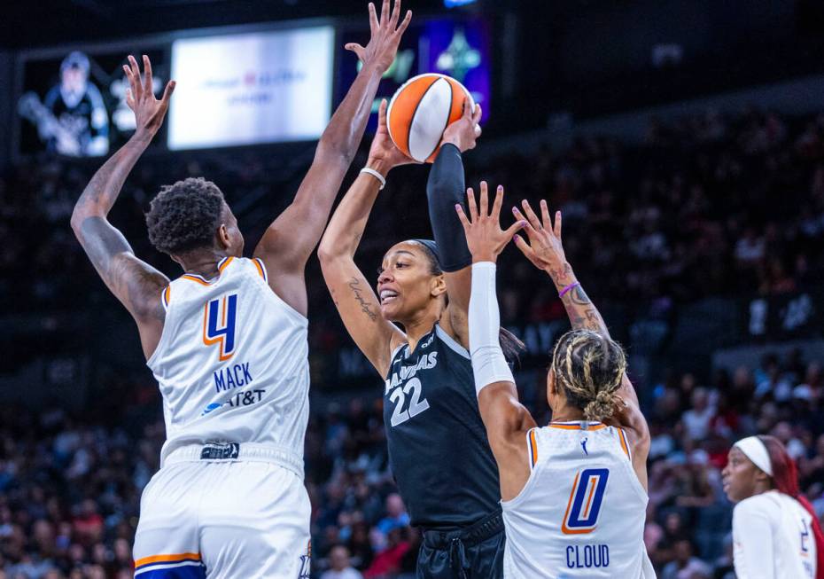 Aces center A'ja Wilson (22) looks to pass between Phoenix Mercury forward Natasha Mack (4) and ...