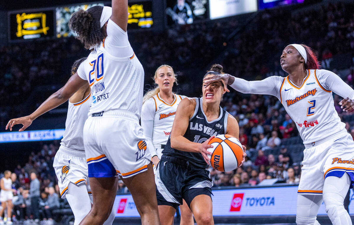 Aces guard Kelsey Plum (10) takes a hand to the face from Phoenix Mercury guard Kahleah Copper ...