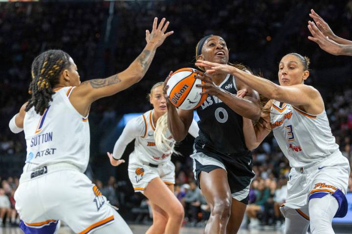 Aces guard Jackie Young (0) is grabbed on the arm as she drives the laneagainst Phoenix Mercury ...