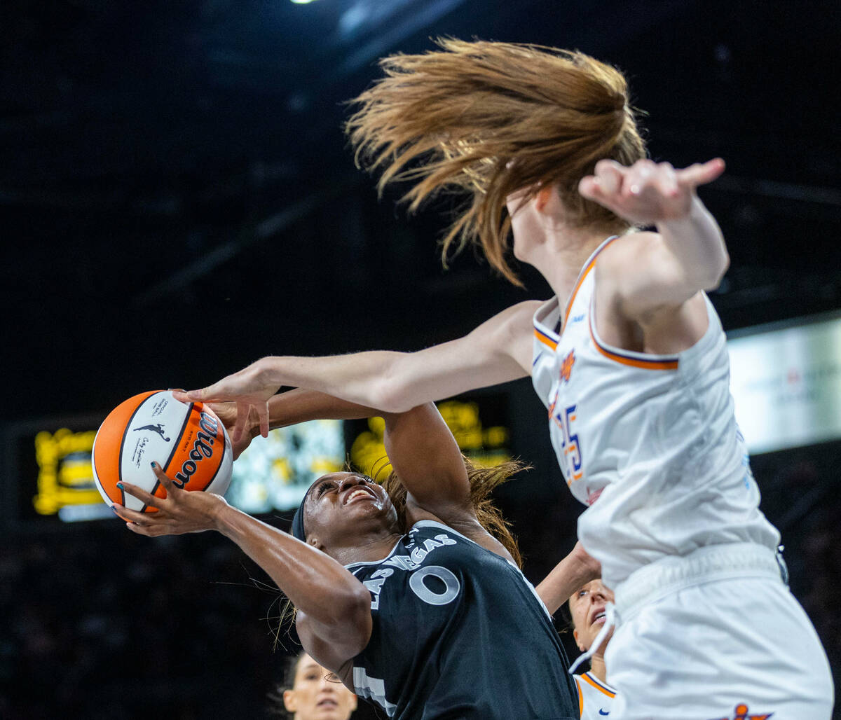 Aces guard Jackie Young (0) battles with Phoenix Mercury forward Morgan Bertsch (25) under the ...