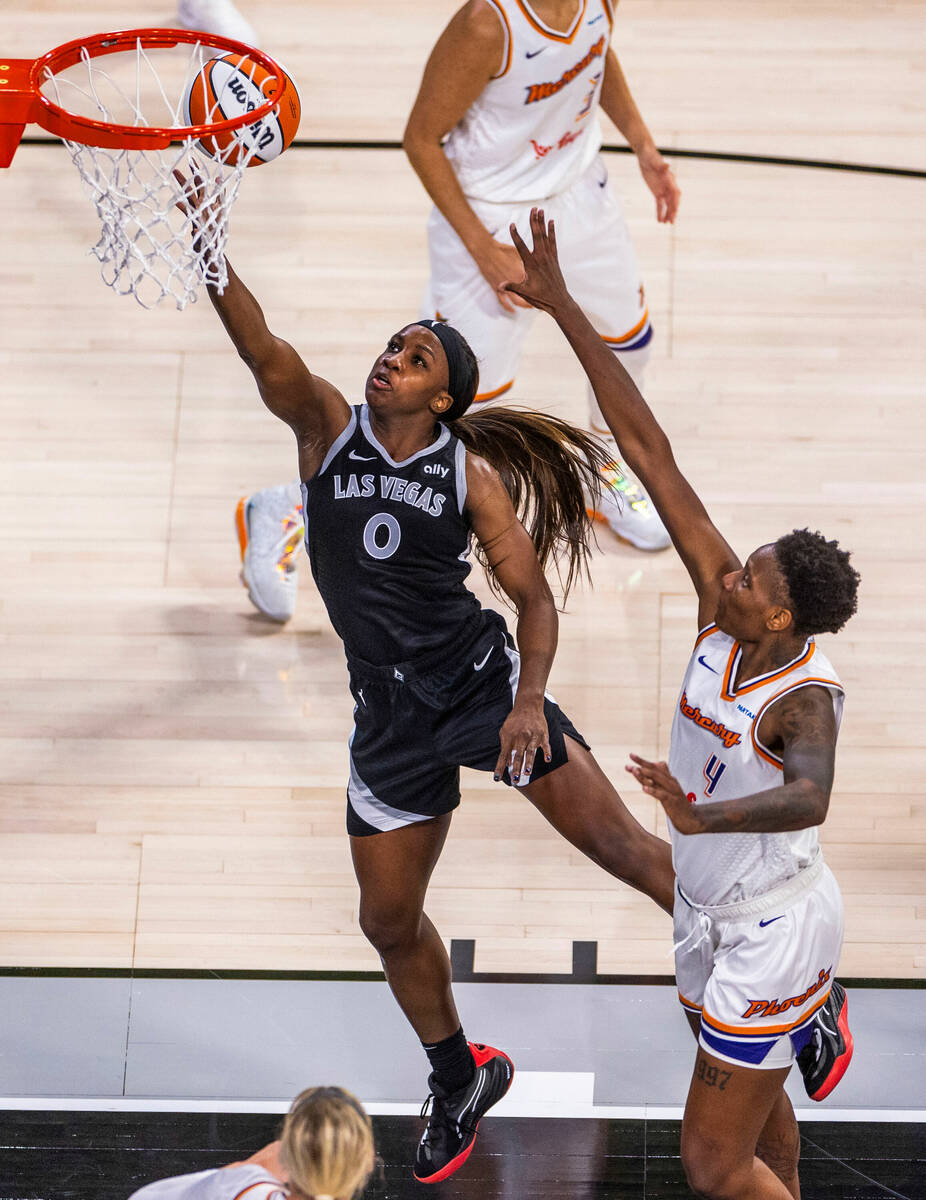 Aces guard Jackie Young (0) gets inside of Phoenix Mercury forward Natasha Mack (4) for a layup ...