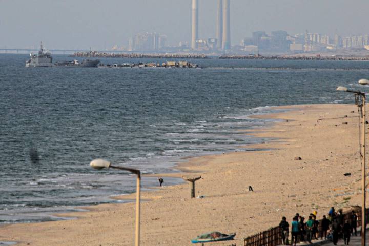 Palestinians watch as a ship transporting international humanitarian aid docks at the U.S.-buil ...