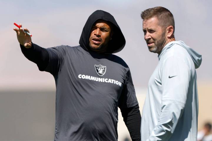 Raiders head coach Antonio Pierce, left, discusses with Scott Turner, team's pass game coordina ...