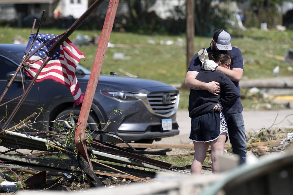 Local residents hug in front of their tornado damaged home, Wednesday, May 22, 2024, in Greenfi ...