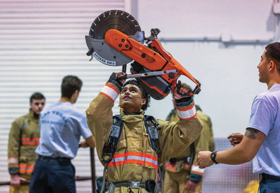 Participant Nainoa Reyes, 17, holds up a rescue saw to feel the weight while assisted by explor ...