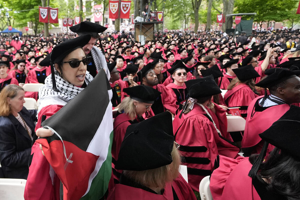 Graduating students chant as they depart commencement in protest to the 13 graduating seniors w ...