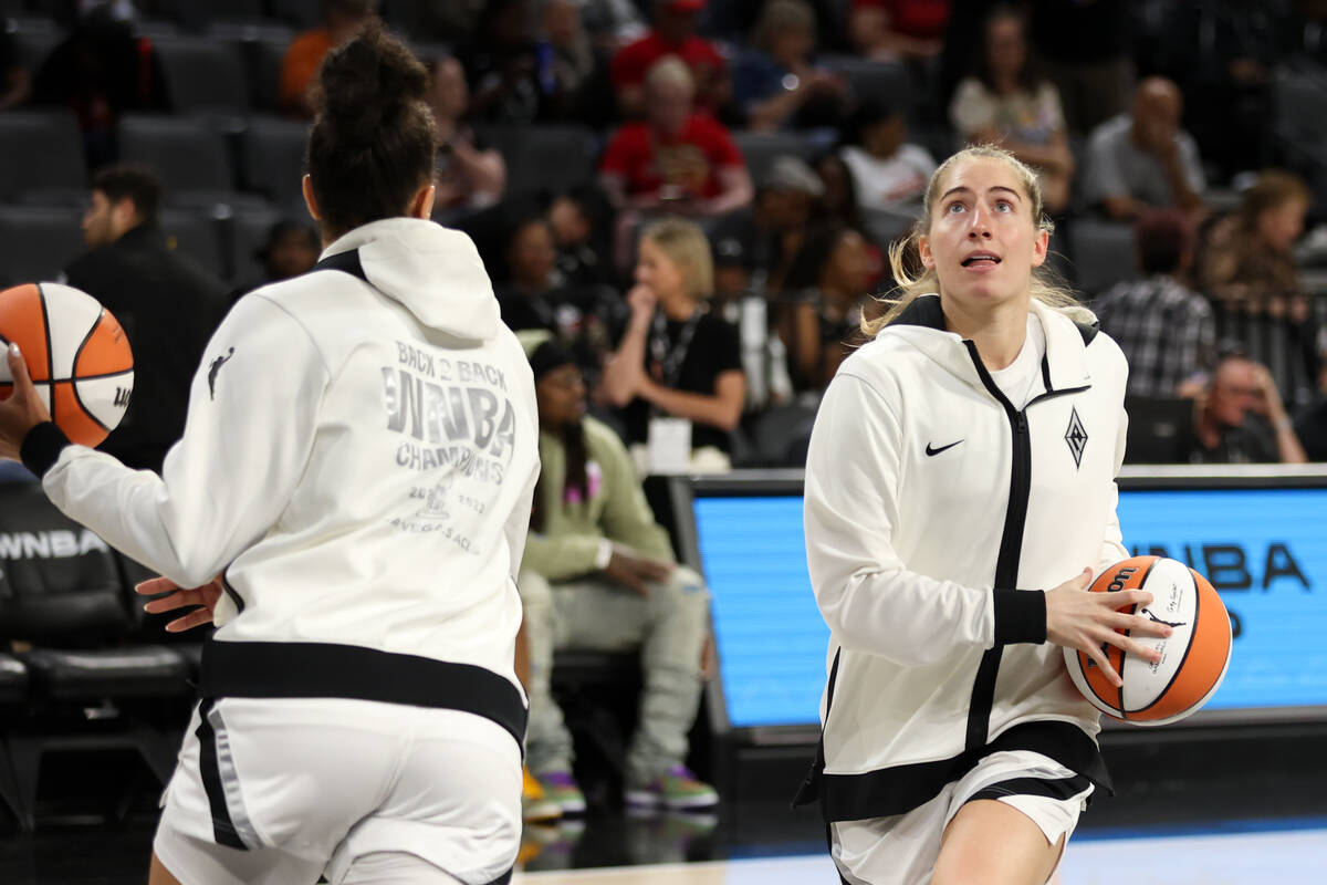 Las Vegas Aces guard Kate Martin, right, warms up before the the second half of a WNBA basketba ...