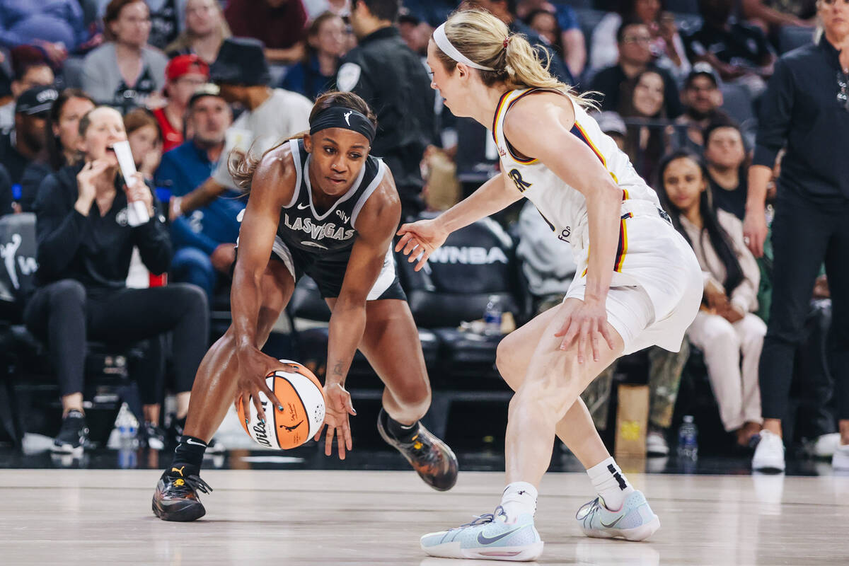Aces guard Jackie Young (0) fights to keep the ball in her possession as Indiana Fever guard Le ...