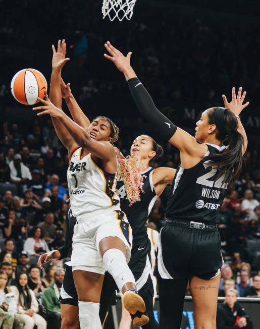 Indiana Fever forward Aliyah Boston (7) grabs the ball for a rebound as Aces center A'ja Wilson ...