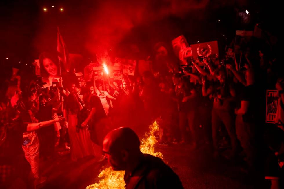 Demonstrators burn fire during a protest against Israeli Prime Minister Benjamin Netanyahu's go ...