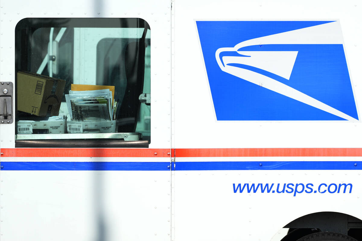FILE - Letters and packages are loaded on a U.S. Postal Service truck parked outside a post off ...
