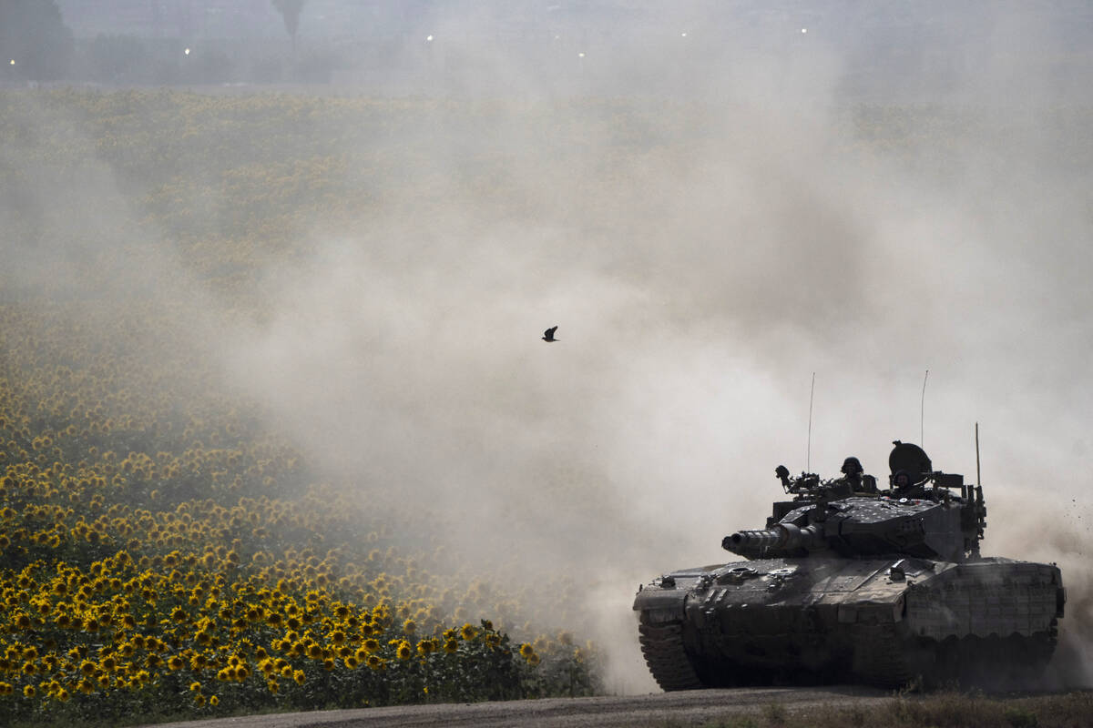 Israeli soldiers move on the top of a tank near the Israeli-Gaza border, as seen from southern ...