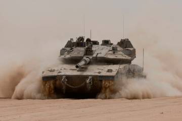 An Israeli army tank rolls along Israel's southern border with the Gaza Strip on Tuesday, May 2 ...