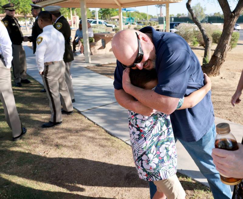 Grayson, 9, grandson of fallen Las Vegas police Sgt. Henry Prendes, gets a hug from family frie ...