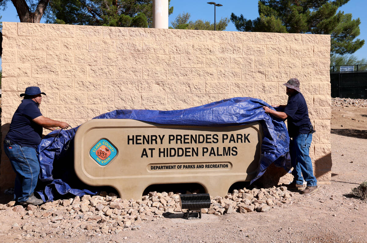 Clark County workers unveil the new sign at Henry Prendes Park at Hidden Palms during a ceremon ...