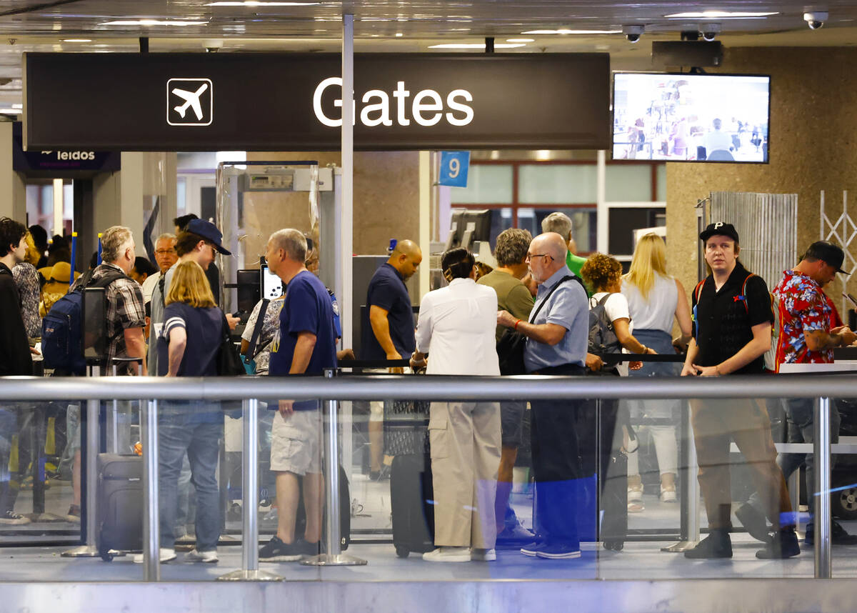 Departing passengers wait in line for security screening at Terminal-1 of Harry Reid Internatio ...