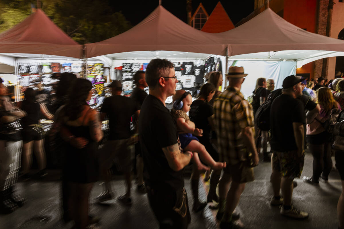 A festival attendee carrying a baby passes by during the Punk Rock Bowling music festival at Do ...
